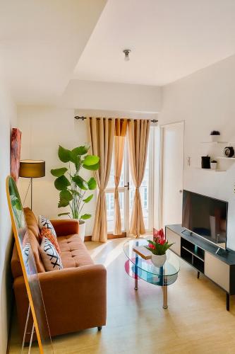 a living room with a couch and a glass table at Vivaldi Residences Cubao VB Infinity Stay-Cubao in Manila