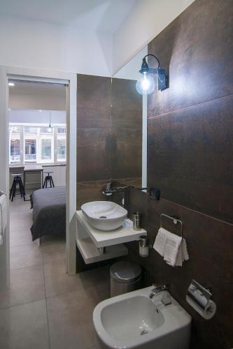 a bathroom with a sink and a toilet and a bed at Relais Castel Nuovo in Naples