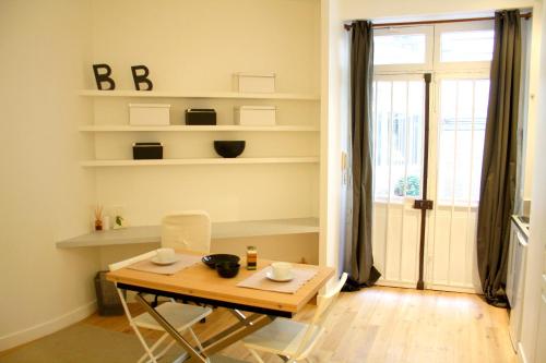 une salle à manger avec une table et des chaises et une fenêtre dans l'établissement Rue d'Argenteuil VII - Palais Royal, à Paris