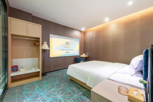 a hotel room with a bed and a projection screen at Trendy Romantic Hotel International Guangzhou Baoneng Performing Arts Center Science City Metro Station Branch - Free Deliver Service to Guangzhou Baiyun International Airport & Free Deliver Service to Canton Fair Complex During Canton Fair Period in Guangzhou