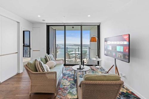 a living room with a couch and chairs and a tv at CASSA MQ - Oceanview 2BR Southport Gem Managed by The Cassa in Gold Coast
