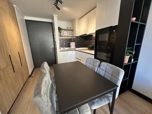 ein Esszimmer mit Tisch und Stühlen in einer Küche in der Unterkunft Oceana Suites San Eugenio, Ñuñoa in Santiago
