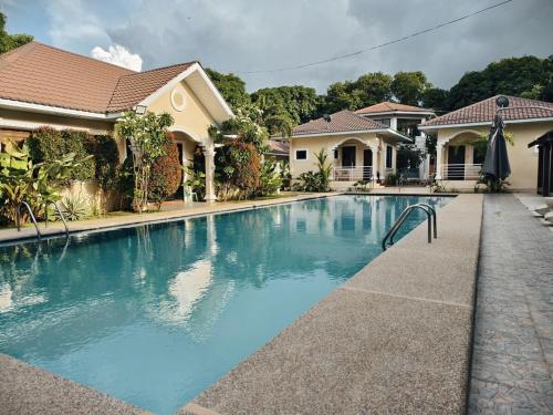 a swimming pool in front of a house at Grand Suite at Mamanorms' Farm 