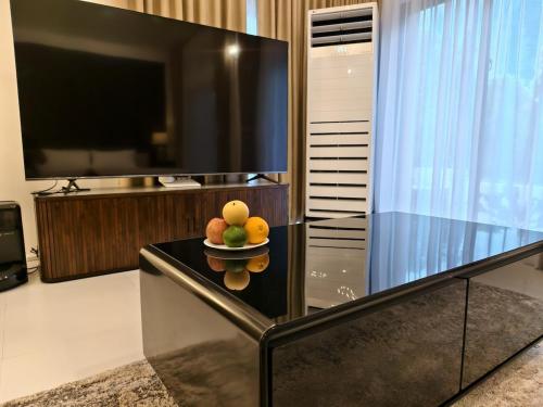 a bowl of fruit on a table with a television at Grand Suite at Mamanorms' Farm 