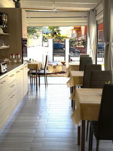 a restaurant with tables and chairs and a kitchen at Bentus B&B in Villasimius