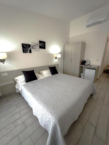 a bedroom with a large white bed in a room at Bentus B&B in Villasimius