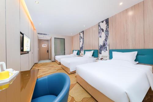 a hotel room with two beds and a blue chair at Trendy Romantic Hotel International Guangzhou Baoneng Performing Arts Center Science City Metro Station Branch - Free Deliver Service to Guangzhou Baiyun International Airport & Free Deliver Service to Canton Fair Complex During Canton Fair Period in Guangzhou