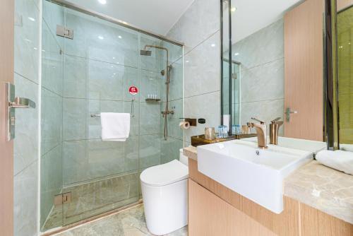a bathroom with a toilet and a sink and a shower at Trendy Romantic Hotel International Guangzhou Baoneng Performing Arts Center Science City Metro Station Branch - Free Deliver Service to Guangzhou Baiyun International Airport & Free Deliver Service to Canton Fair Complex During Canton Fair Period in Guangzhou