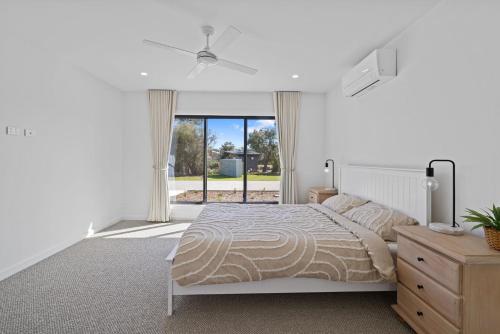 a bedroom with a bed and a ceiling fan at Wirilda Seaside Escape in Inverloch