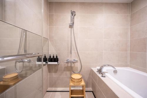 a bathroom with a shower and a tub and a toilet at Takanawa Hanakohro - in Grand Prince Hotel Takanawa in Tokyo