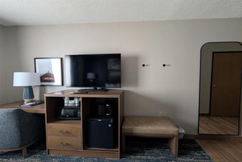 a hotel room with a television and a chair at Super 8 by Wyndham Perham in Perham