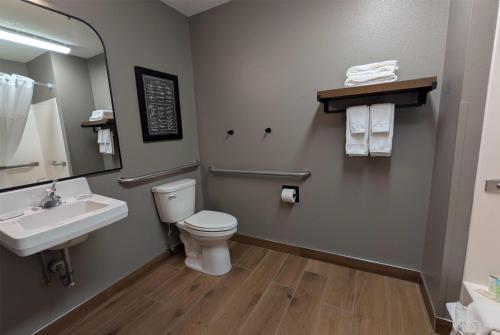a bathroom with a toilet and a sink and a mirror at Super 8 by Wyndham Perham in Perham