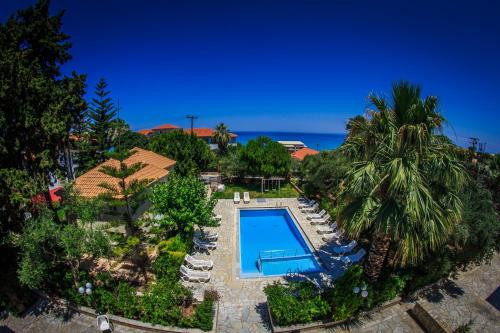 an aerial view of a villa with a swimming pool and palm trees at Chryssi Akti Hotel in Argassi