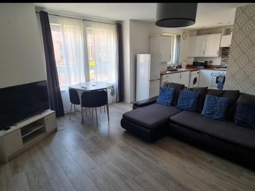 a living room with a couch and a table at City, Celtic park & Emirates Stadium Apartment, for families or age over 23 in Glasgow