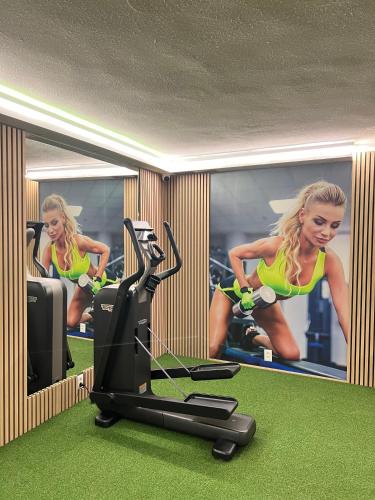 a rendering of a gym with a woman running on a treadmill at WX Hotel in Bratislava
