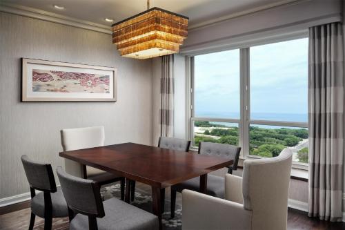 a dining room with a table and chairs and a large window at Hilton Chicago in Chicago