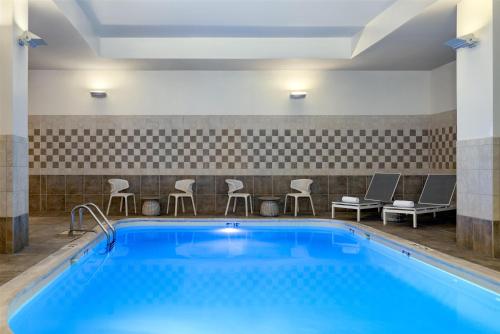a pool in a hotel room with chairs and tables at Hilton Garden Inn Indianapolis Downtown in Indianapolis