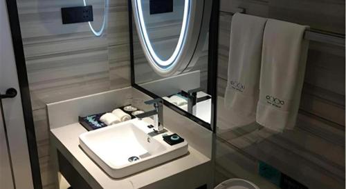 une salle de bains avec un lavabo blanc et un miroir dans l'établissement Xana Hotelle XiAn Gig Wild Goose Pagoda Branch, à Xi'an