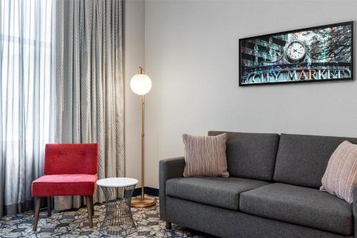 a living room with a couch and a red chair at Hilton Garden Inn Indianapolis Downtown in Indianapolis