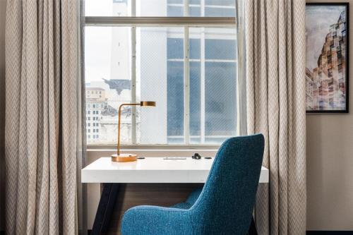 a desk with a blue chair next to a window at Hilton Garden Inn Indianapolis Downtown in Indianapolis