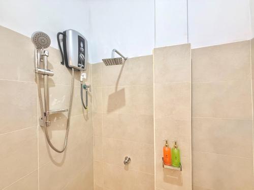 a bathroom with a shower with a phone and bottles at CAO Ella in Ella