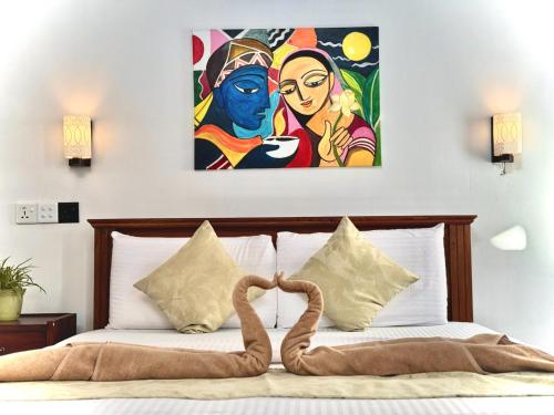 a bedroom with a bed with a painting on the wall at CAO Ella in Ella