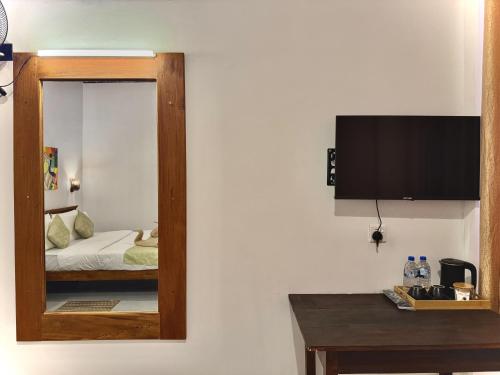 a mirror on a wall in a room with a bed at CAO Ella in Ella