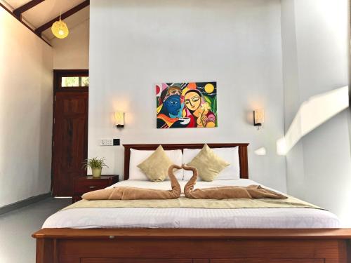 a bedroom with a bed with a painting on the wall at CAO Ella in Ella