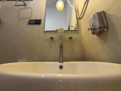 a white sink in a bathroom with a mirror at CAO Ella in Ella