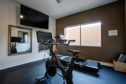 a room with a gym with a treadmill and a mirror at Arroyo Pinion Hotel, an Ascend Collection Hotel in Sedona