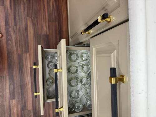 a cabinet filled with plates and bowls in a room at شقة مفروشة أنيقة للإيجار اليومي في مكة -الشرائع in Ash Sharāʼi‘