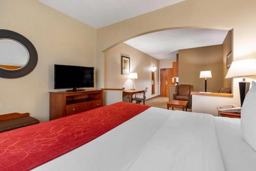 a hotel room with a bed and a flat screen tv at Comfort Suites North Dallas in Dallas