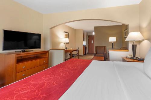a hotel room with a bed and a flat screen tv at Comfort Suites North Dallas in Dallas