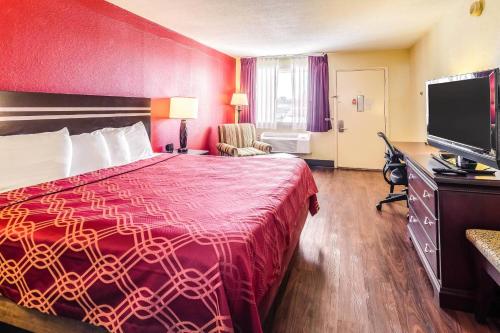 a hotel room with a bed and a flat screen tv at Econo Lodge Christiansburg-Blacksburg I-81 in Christiansburg