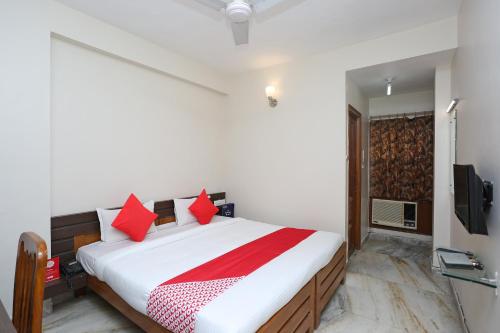 a bedroom with a large bed with red pillows at Hotel O Vijay Palace in Bhopal