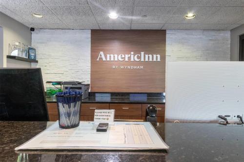 an office with a sign that says american firm on a counter at AmericInn by Wyndham Green Bay East in Green Bay