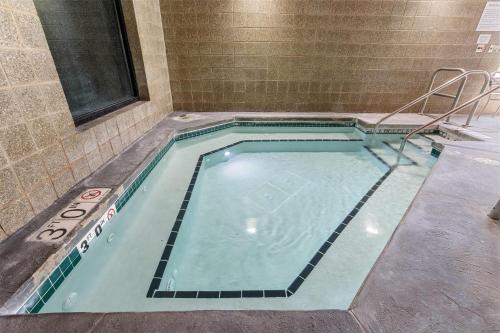 a small swimming pool with a stove in a room at AmericInn by Wyndham Green Bay East in Green Bay