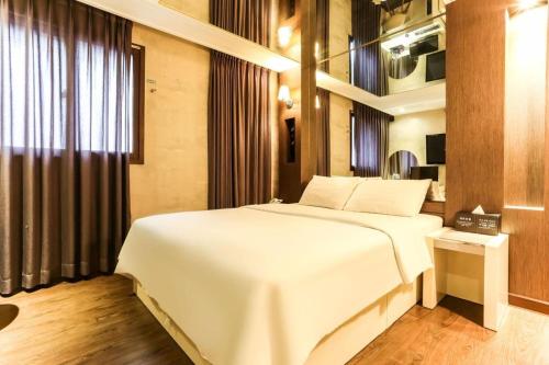 a bedroom with a large white bed and a window at Seven Motel Ansan in Ansan