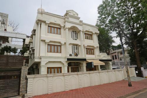 a white house with a fence in front of it at Hotel O Vijay Palace in Bhopal