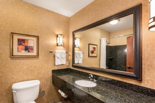 a bathroom with a toilet and a sink and a mirror at Comfort Suites Moses Lake in Moses Lake