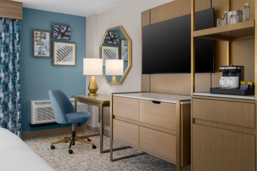 a hotel room with a bed and a desk and a chair at Doubletree By Hilton Wilmington, Nc in Wilmington