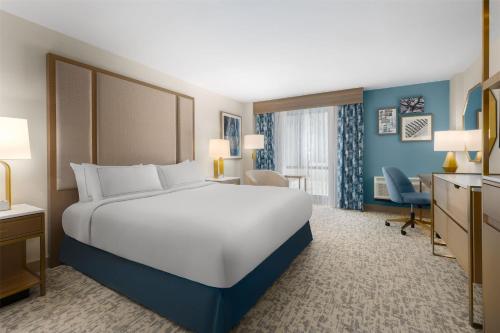 a hotel room with a large bed and a desk at Doubletree By Hilton Wilmington, Nc in Wilmington