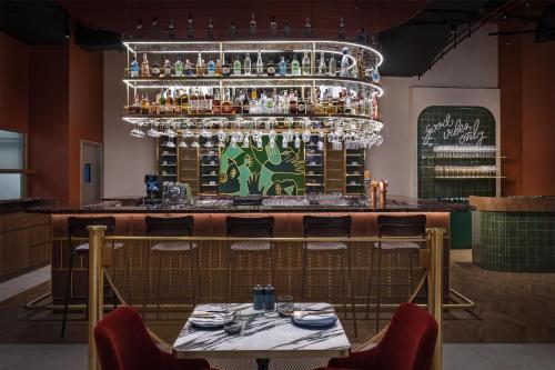 a restaurant with a bar with a table and chairs at Embassy Suites By Hilton Dubai Business Bay in Dubai