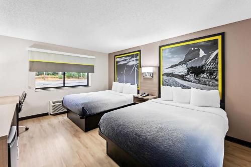 Una habitación de hotel con dos camas y una ventana. en Super 8 by Wyndham Marston, en Marston