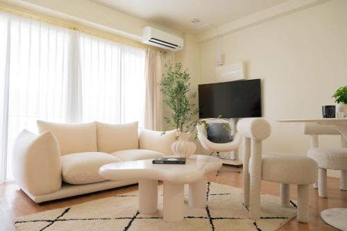 a living room with a white couch and a table at Maison du Voyage New-Elegant villa 3min from Kadena Air Base Gate 3 in Okinawa City