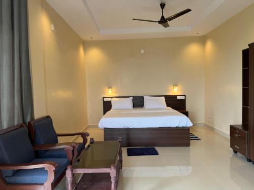 a hotel room with a bed and two chairs at Biglaand Dew Castle in Pīrmed