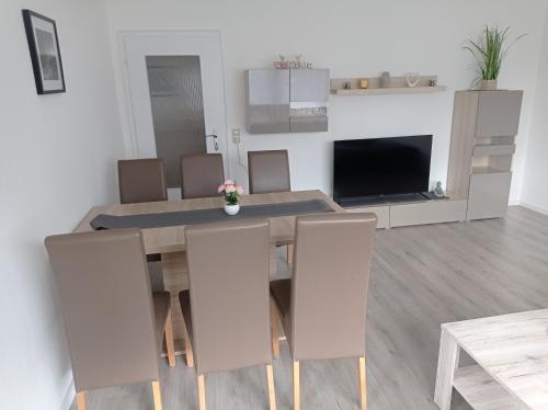 a dining room with a table and chairs and a tv at Work and Stay Plettenberg 6 Betten Dusche Küche Balkon Garten in Plettenberg