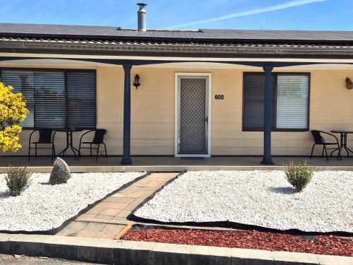 a house with a porch with chairs and a table at Tamworth Holiday Park in Tamworth