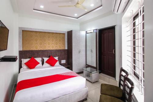 a bedroom with a large bed with red pillows at Hotel O Eagle Fantasy in Vānivilāsa Puram