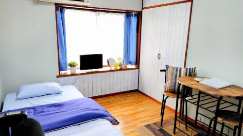 a bedroom with a bed and a desk and a window at Kokusaigakusya Ozukikaikan - Vacation STAY 17326 in Hadano